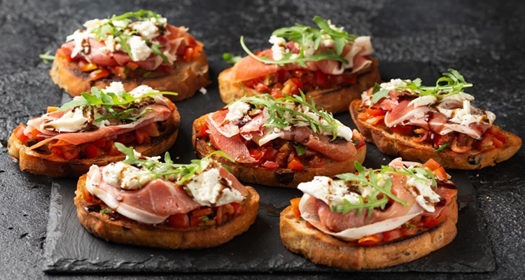 Rohschinken-Tomaten-Bruschetta mit Mozzarella, Rucola und Balsamico